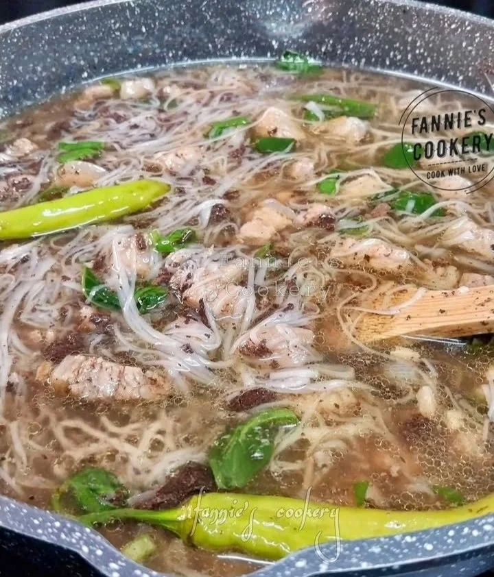 Delicious Pork Batchoy soup served in a bowl, featuring noodles and garnishes.