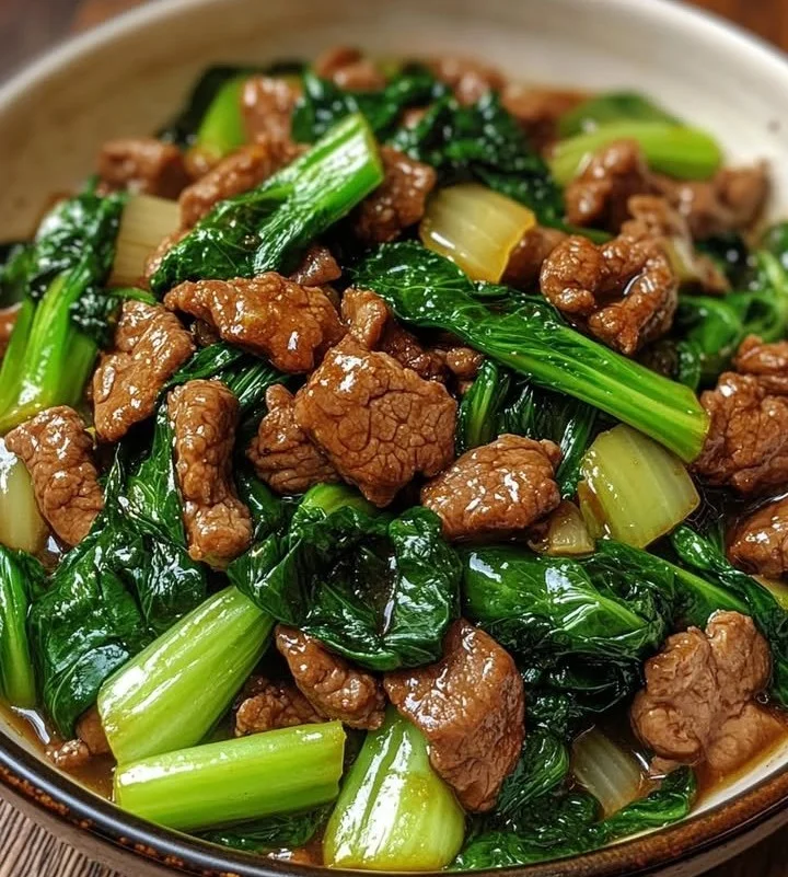 Bok Choy Stir-Fried Beef served in a vibrant dish garnished with herbs.