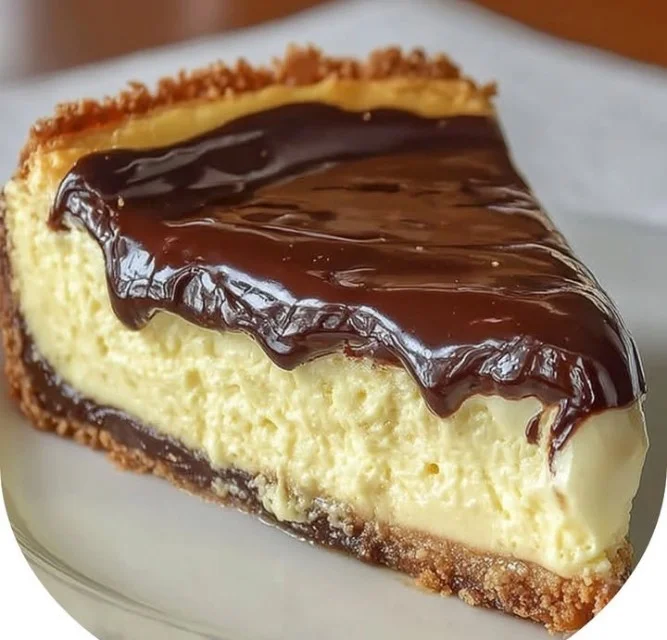 Boston Cream Pie Cheesecake topped with chocolate ganache and cream filling