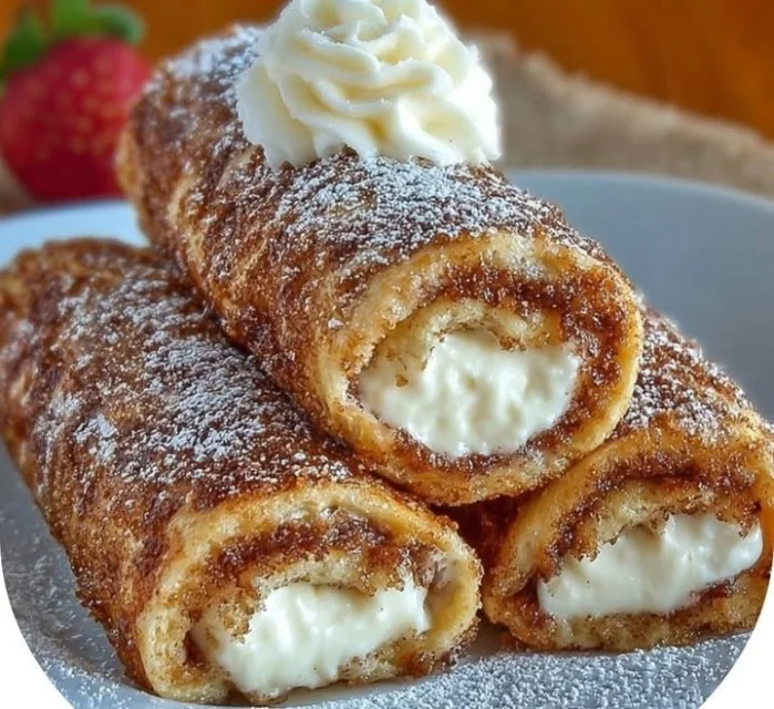 Cinnamon Roll French Toast Roll-Ups topped with icing and fresh berries