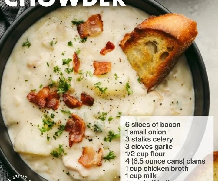 Bowl of rich clam chowder with herbs and crackers on the side