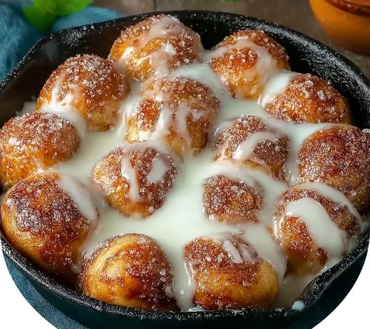 Delicious classic cinnamon roll bites with icing on a wooden board