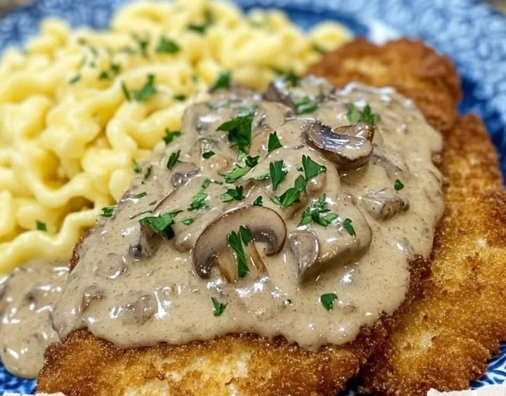 Delicious plate of Hunter's Schnitzel garnished with herbs and served with sides.
