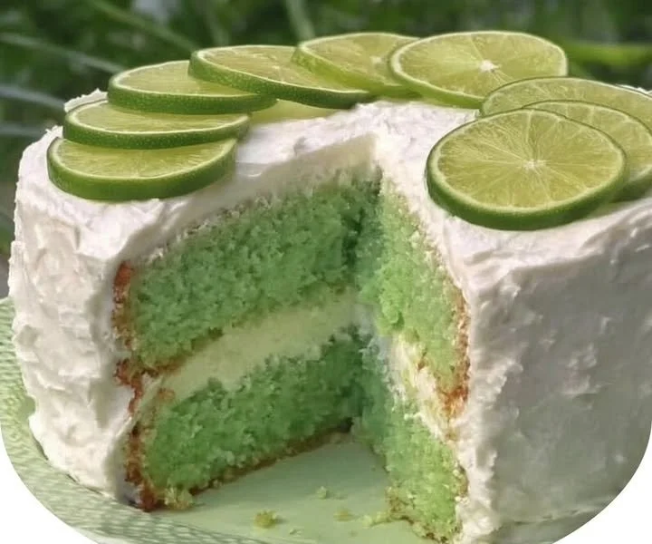 Delicious slice of Key Lime Cake topped with fresh lime zest and cream