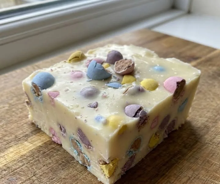 Delicious no-bake Cadbury Egg Fudge topped with colorful candy eggs.