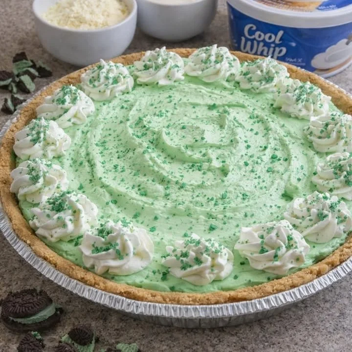 Delicious Shamrock Shake Pie topped with whipped cream and green sprinkles.