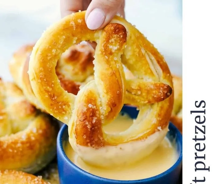 Freshly baked soft pretzels with a golden brown finish, served with mustard dip.