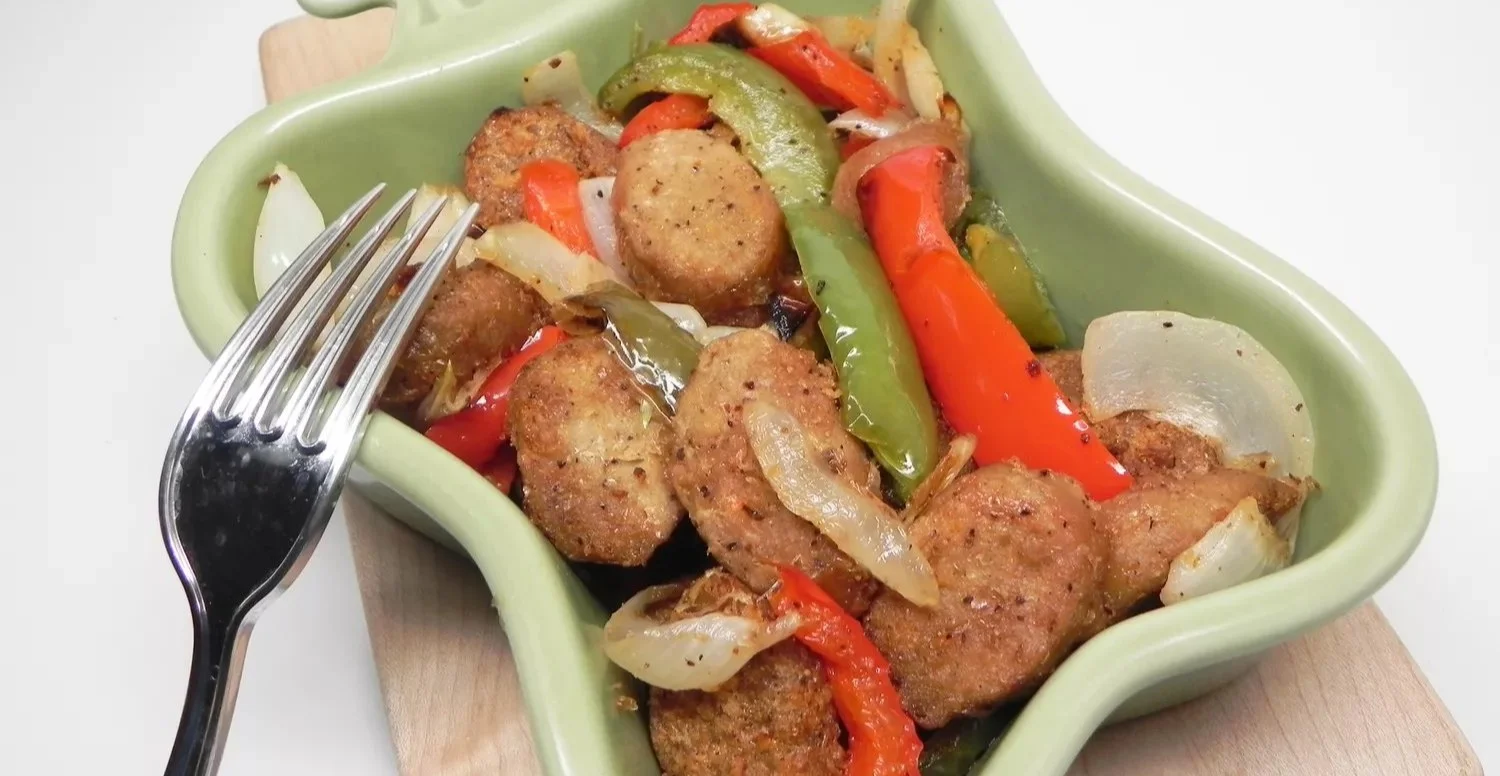 Air Fryer Beyond Meat Brats with sautéed onions and peppers on a plate