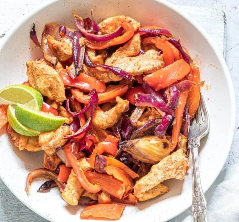Air fryer chicken fajitas served with peppers and onions on a plate