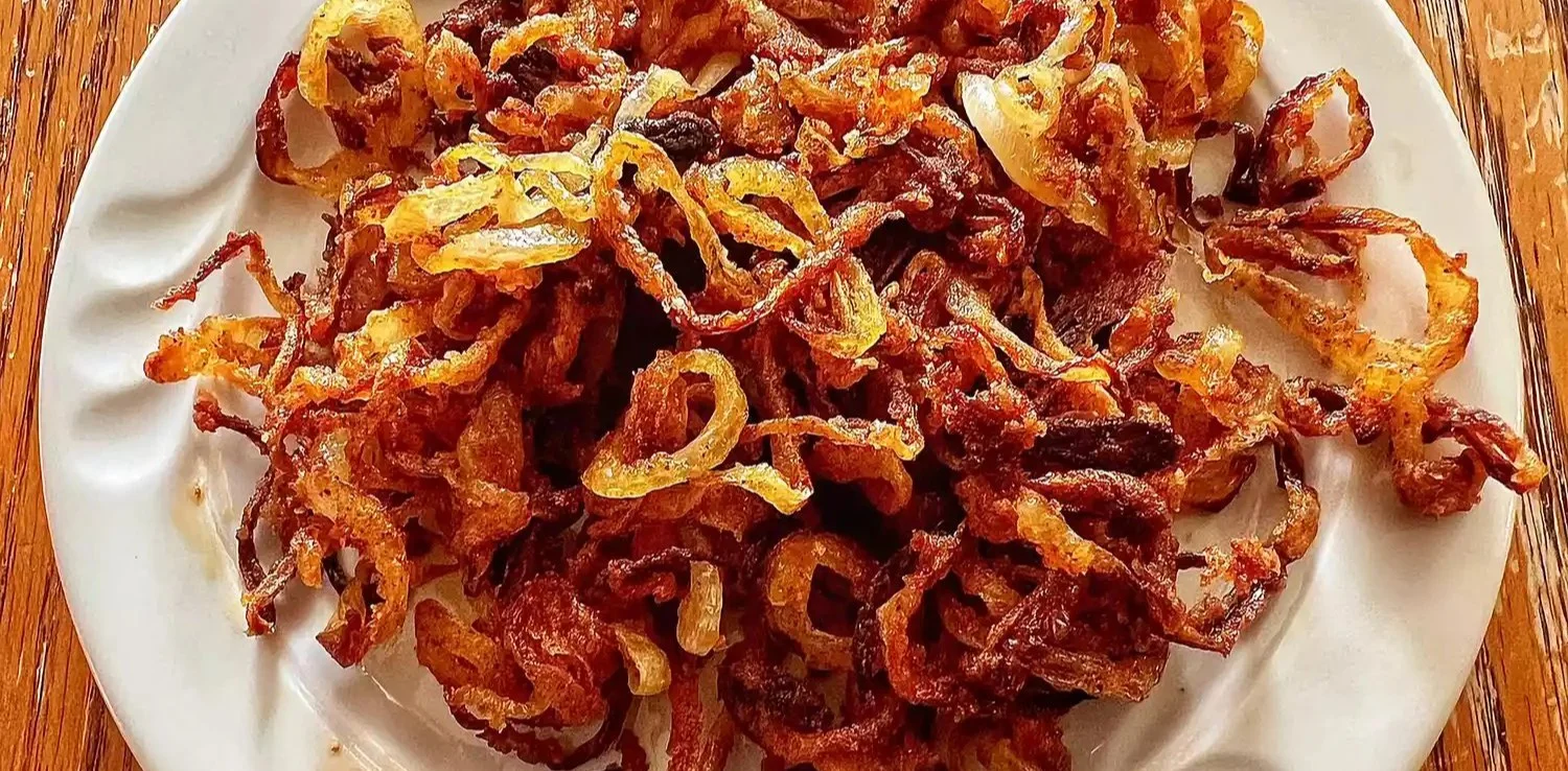 Air fryer crispy onions in a bowl, a tasty garnish for salads and dishes