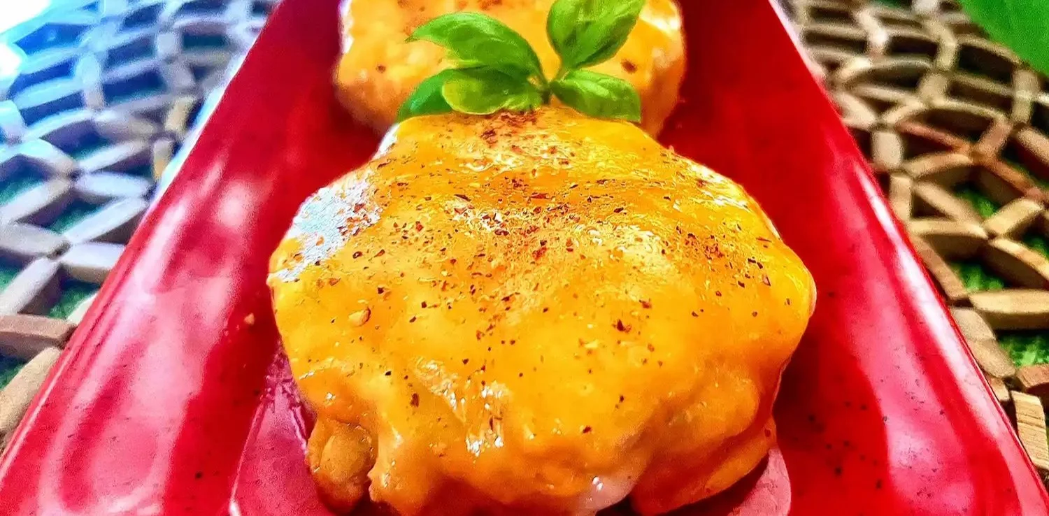 Air Fryer English Muffin Tuna Melt topped with melted cheese and fresh herbs.