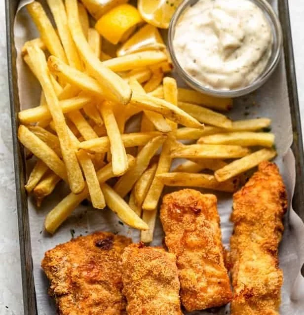 Delicious air fryer fish and chips served with tartar sauce and lemon.