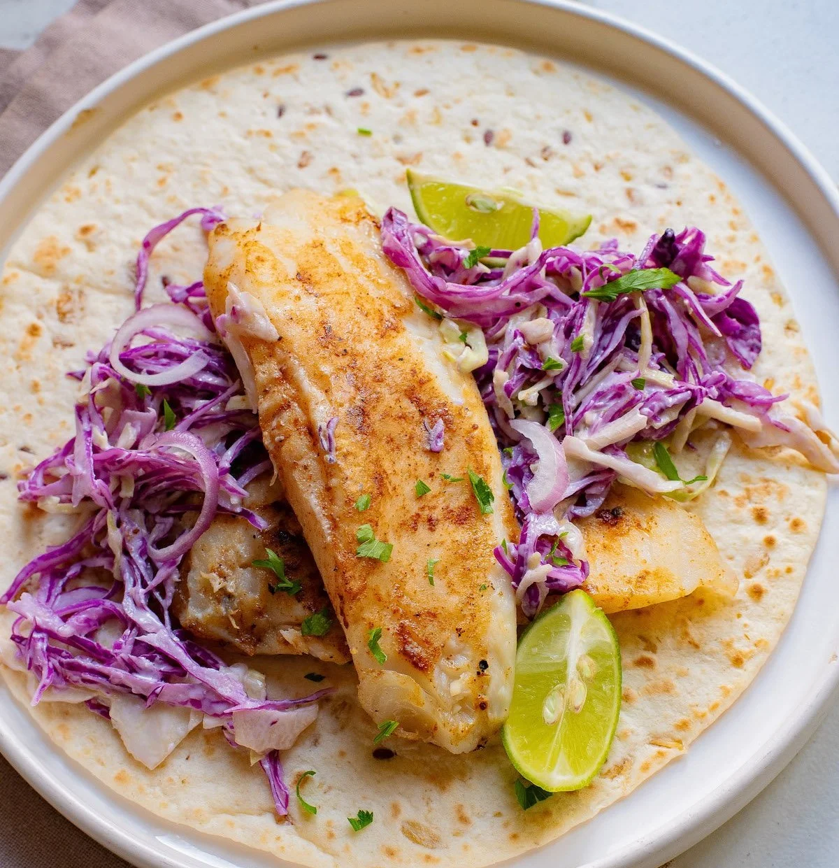 Delicious air fryer fish tacos garnished with lime and cilantro