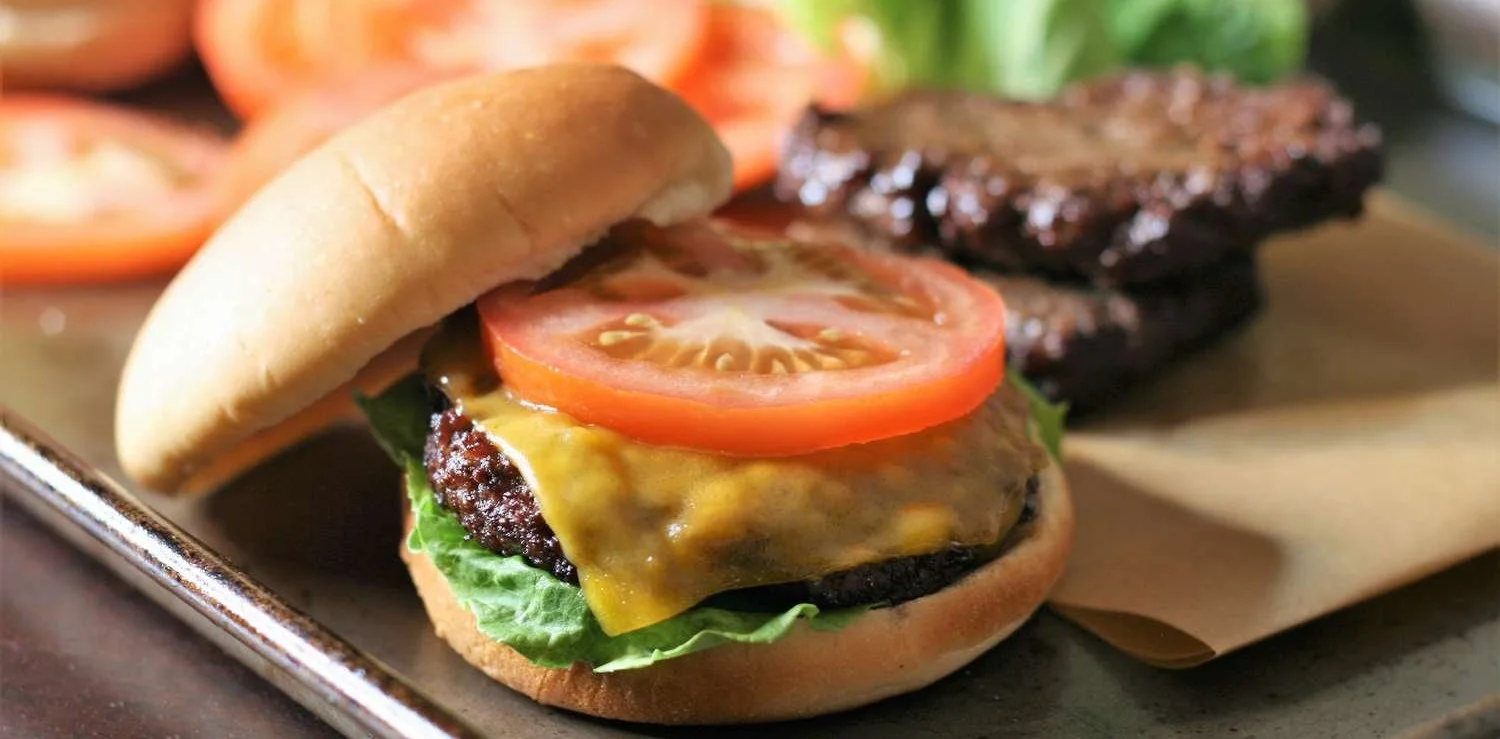 Juicy air fryer hamburgers served with toppings on a wooden board
