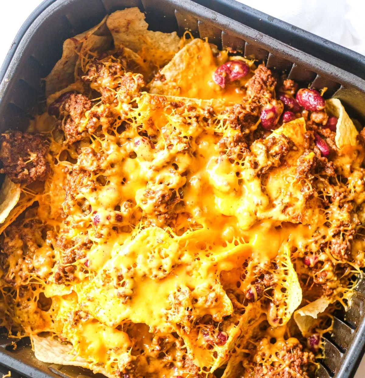 Deliciously crispy air fryer nachos topped with cheese, jalapeños, and salsa