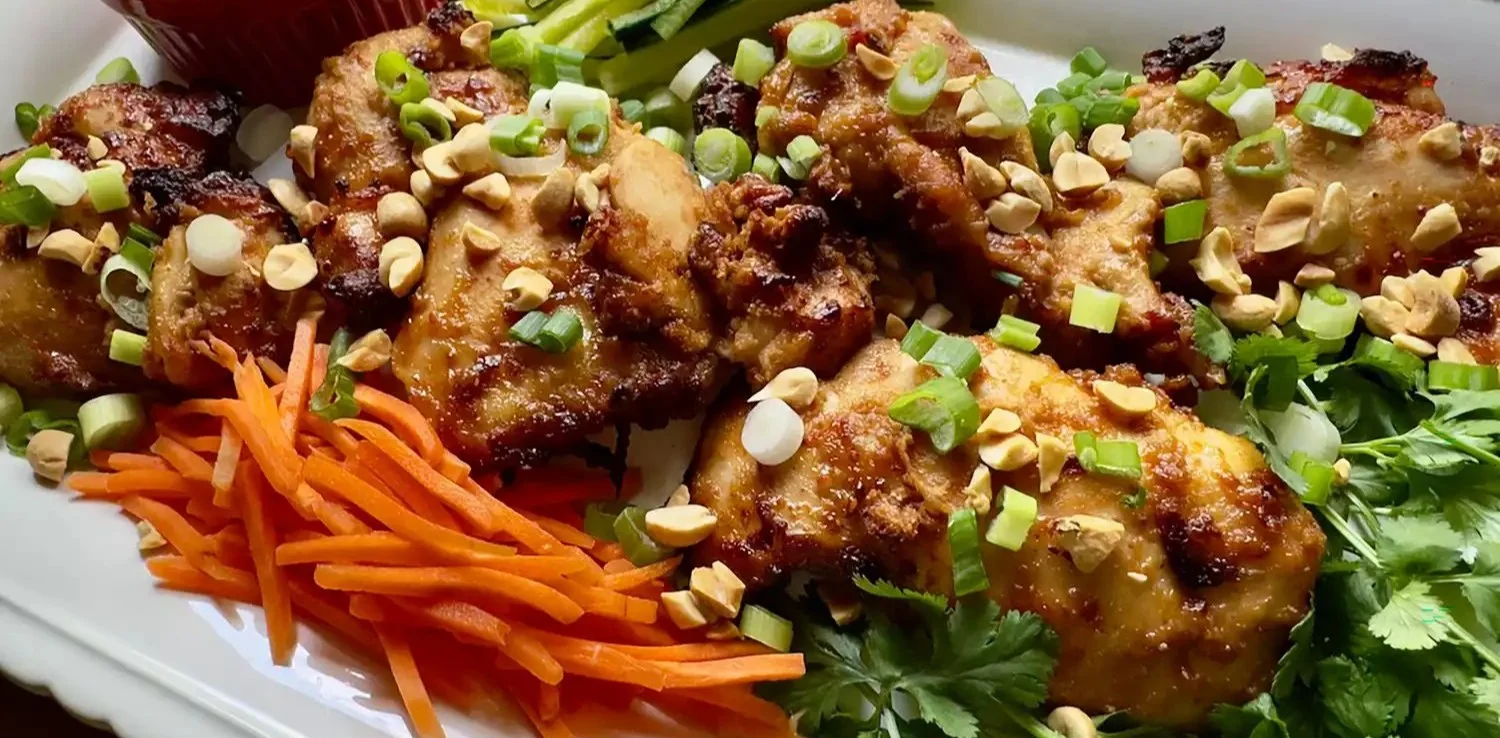 Air fryer peanut chicken served on a plate with a side of vegetables