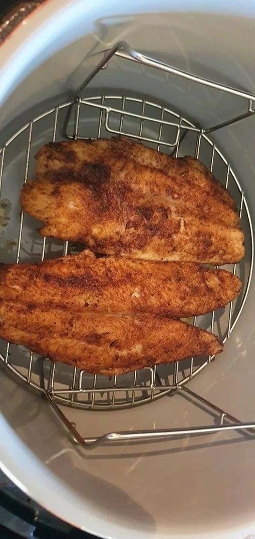 Crispy airfried fish fillet served on a plate with lemon and herbs