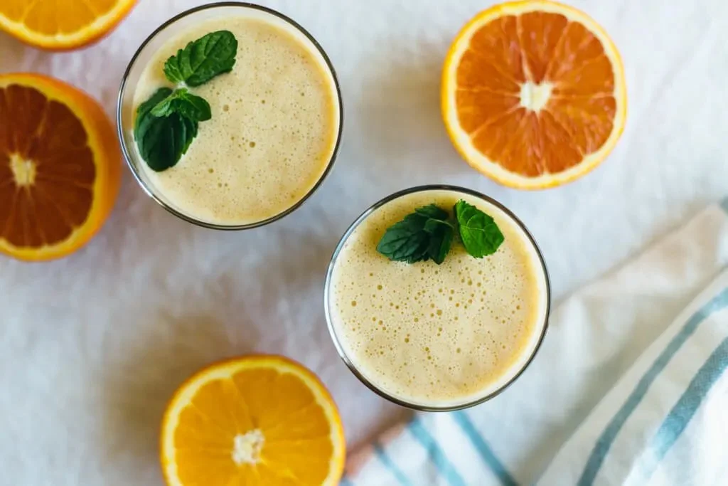 Delicious Almond Orange Smoothie served in a glass with almonds and orange slices