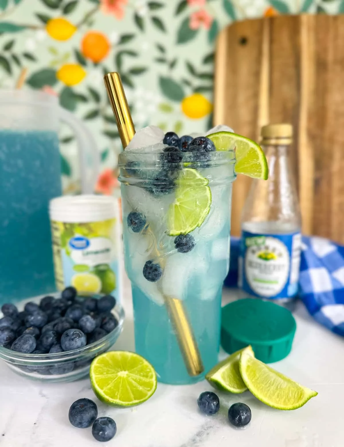 Refreshing Blueberry Limeade in a glass with lime and blueberries.