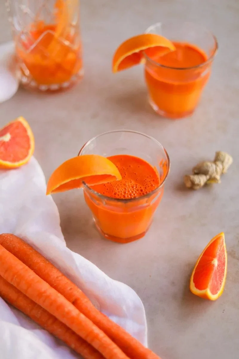 Freshly made carrot orange ginger juice in a glass with vibrant colors.