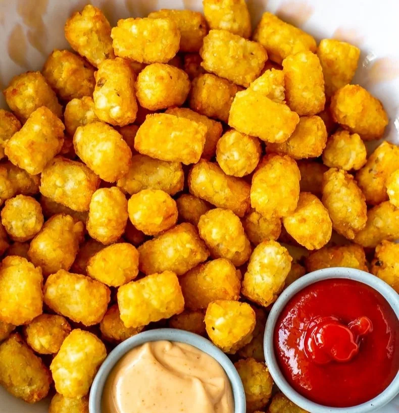 Crispy air fryer tater tots served in a bowl with dipping sauce