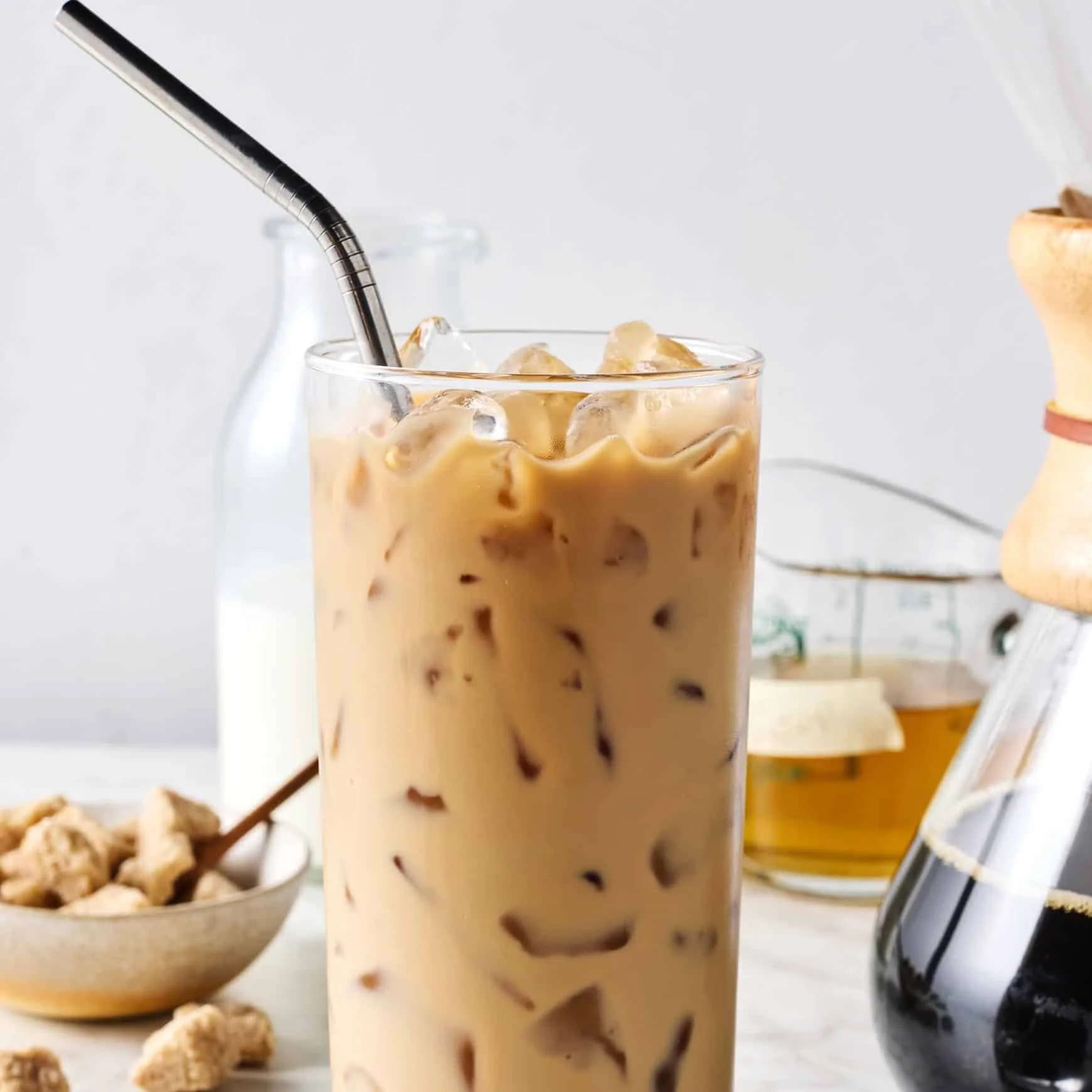 Glass of easy iced coffee with ice cubes and coffee beans beside it