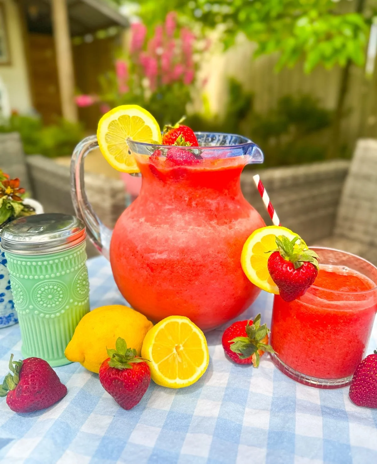 Frozen strawberry lemonade in a glass with fresh strawberries and lemon slices