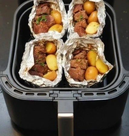 Garlic Butter Steak and Potato Foil Packets served on a grill.