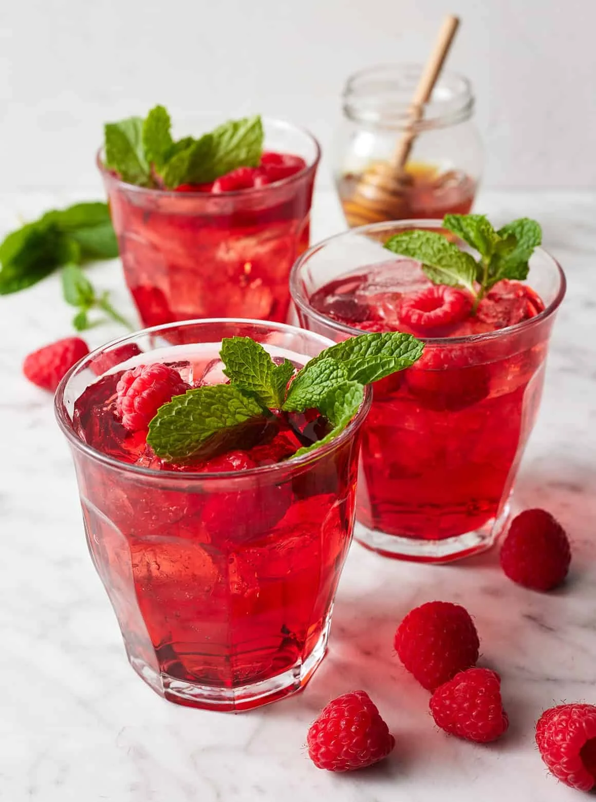 A cup of vibrant red Hibiscus Tea with fresh hibiscus flowers