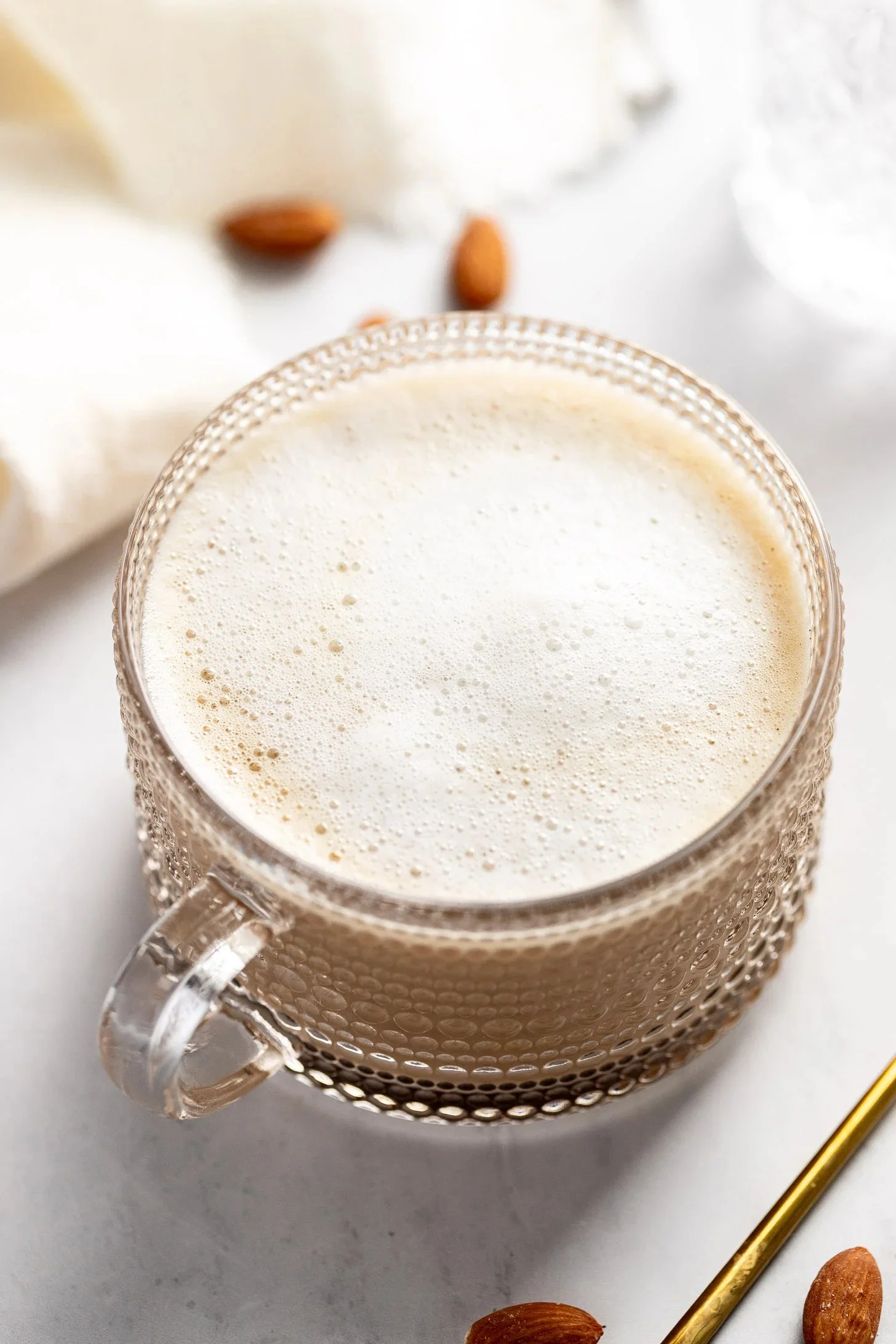 Homemade almond latte served hot and iced in a coffee cup.