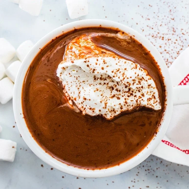 Delicious homemade hot chocolate topped with whipped cream and chocolate shavings
