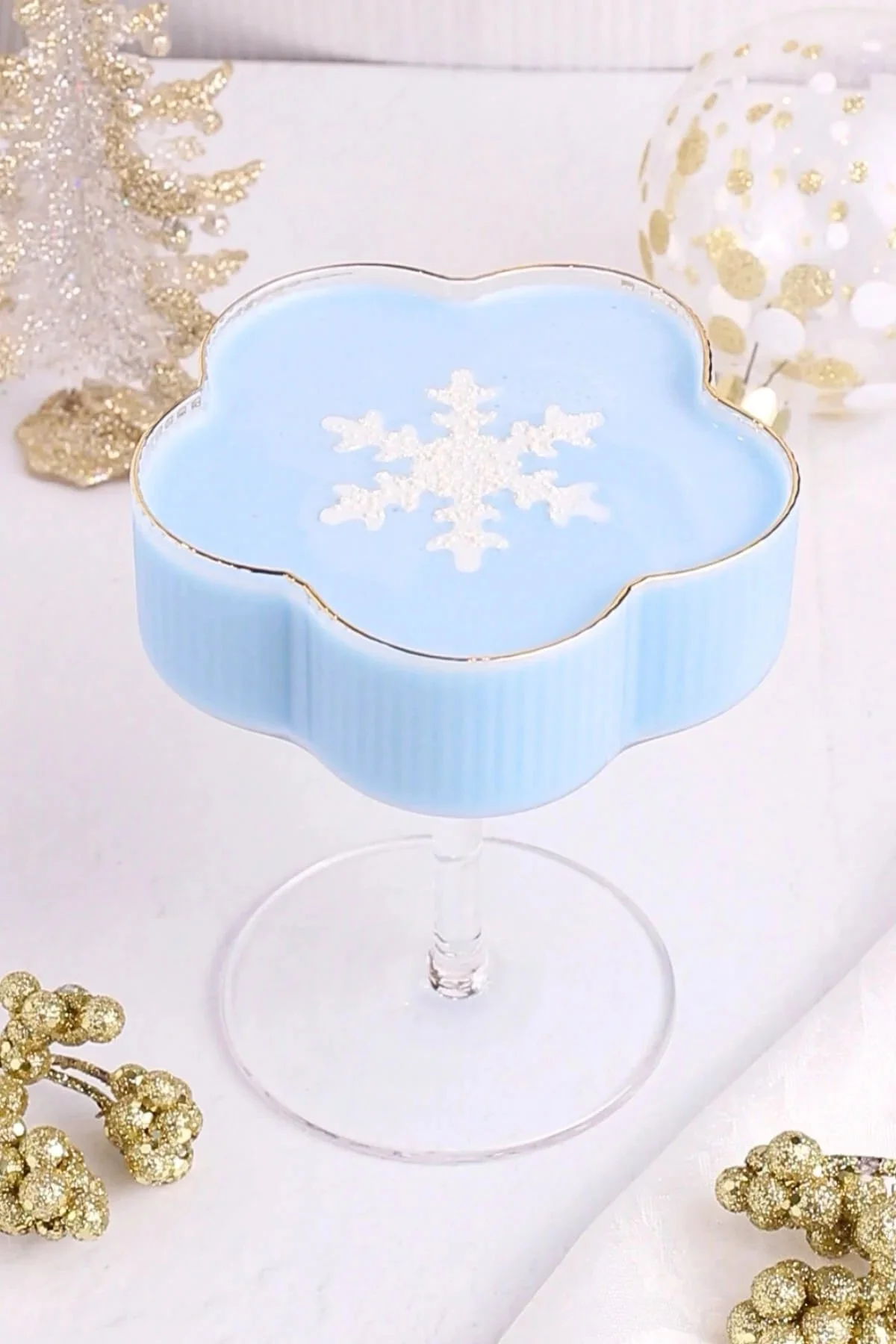 Refreshing Jack Frost Mocktail in a festive glass with blue and white decorations.