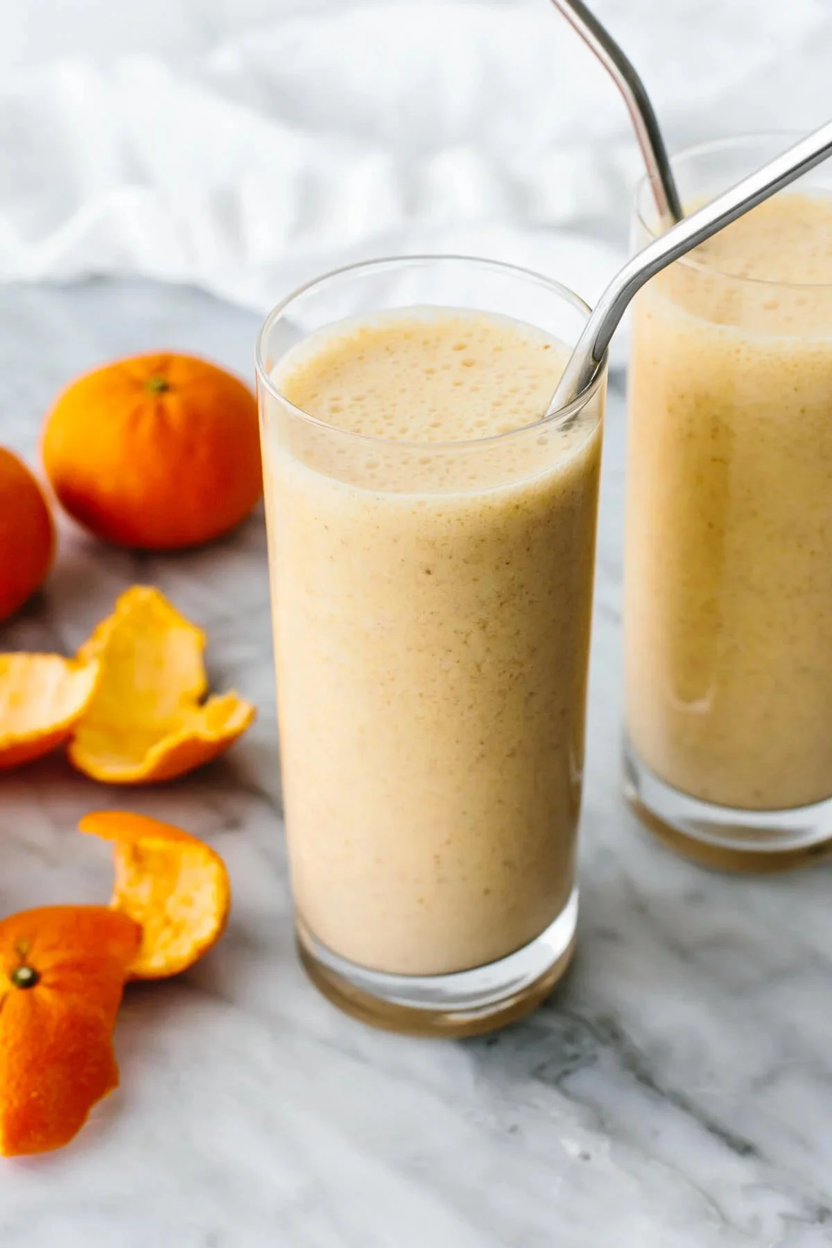 Delicious and healthy Mandarin Breakfast Smoothie in a glass with fresh ingredients