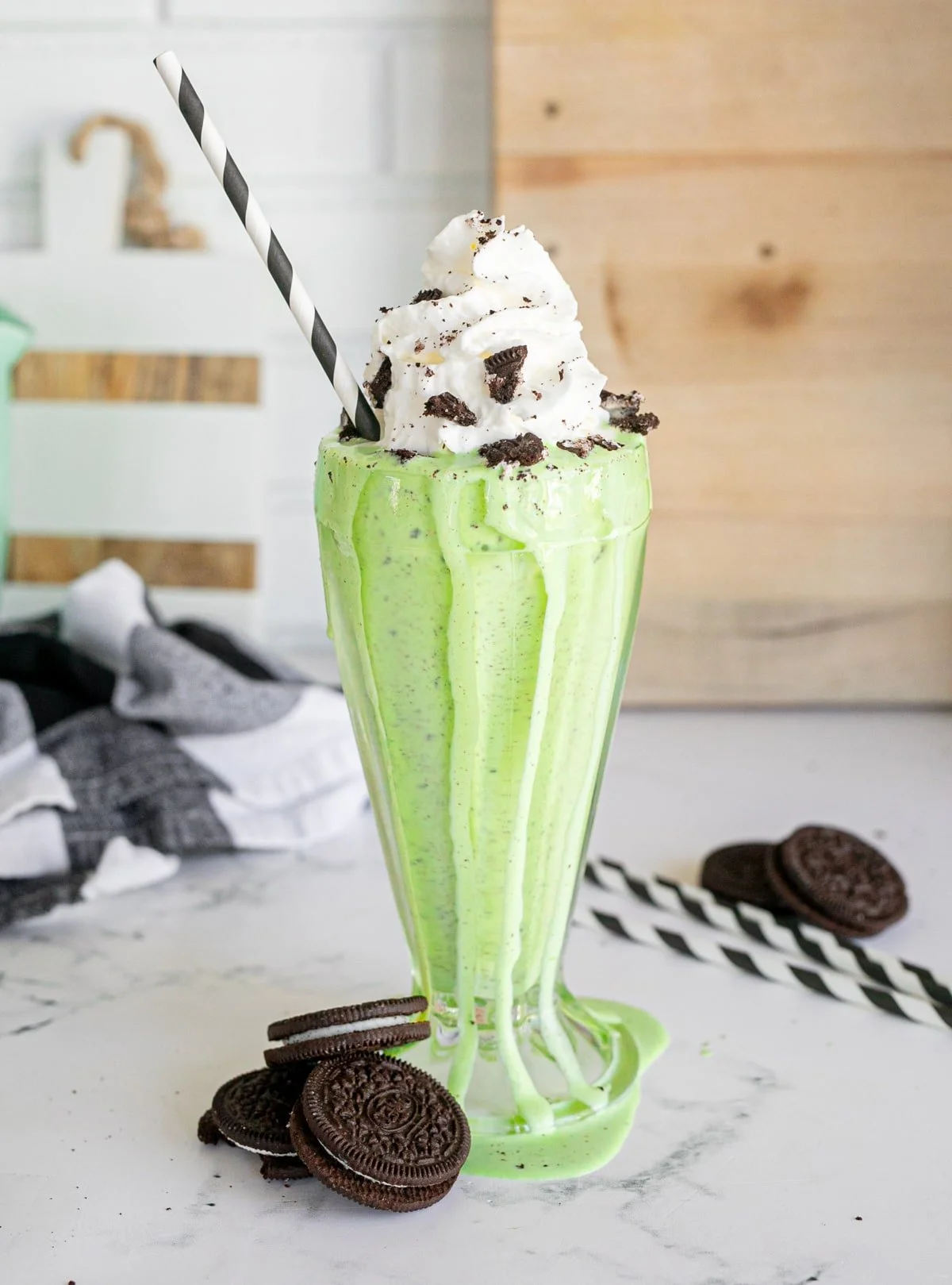 Delicious Mint Oreo Shake served in a glass with whipped cream and chocolate syrup.