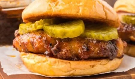 Nashville hot chicken sandwich topped with pickles and spicy sauce on a bun