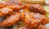 Plate of Nashville hot chicken tenders with spicy seasoning and dipping sauce