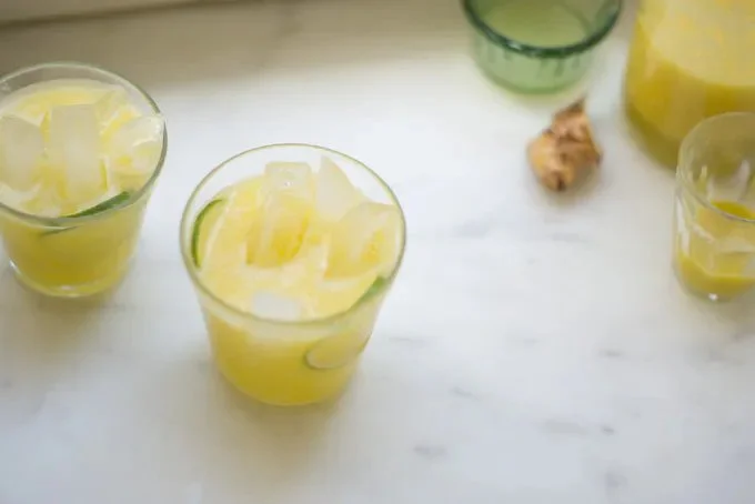 Bottle of refreshing Pineapple Coconut Water served with ice and tropical fruit.