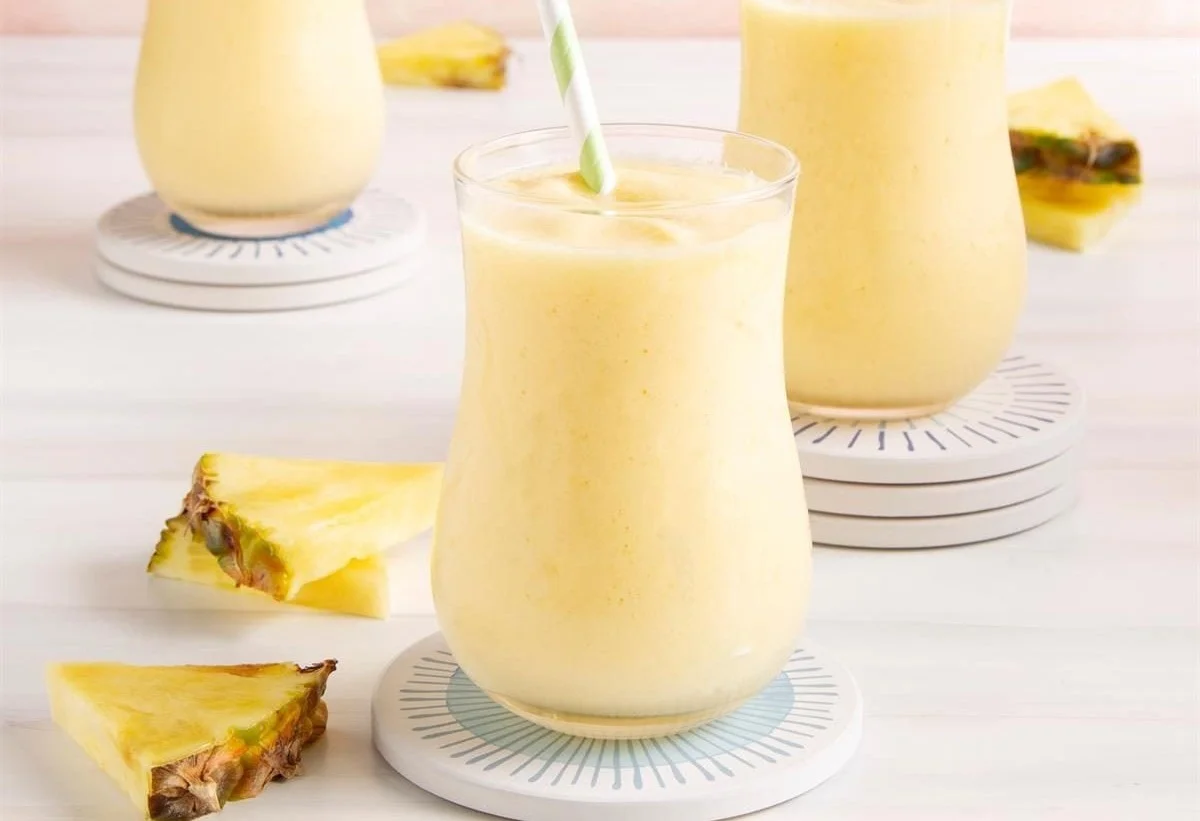 Image of a refreshing pineapple smoothie in a glass with tropical fruit