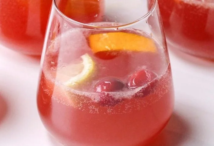 Scarlet Sipper drink in a stylish glass with fresh berries and mint garnish