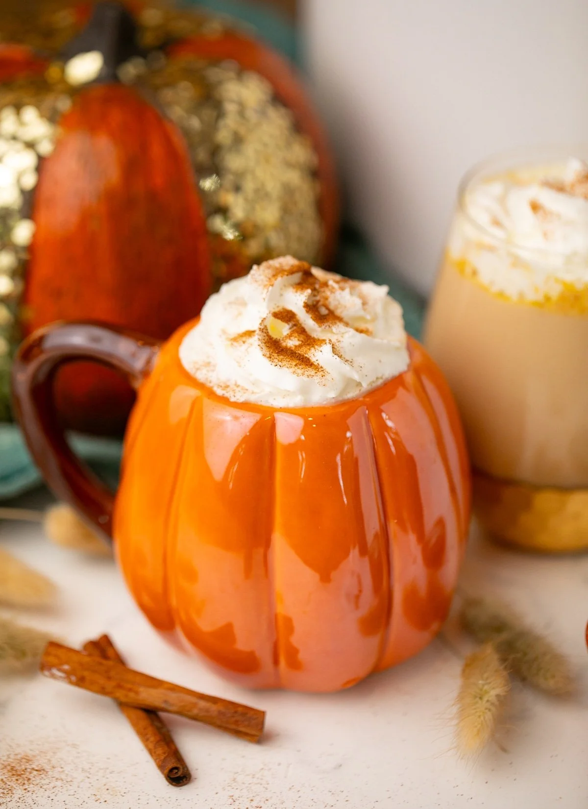 Slow cooker pumpkin spice latte in a cozy mug surrounded by autumn leaves