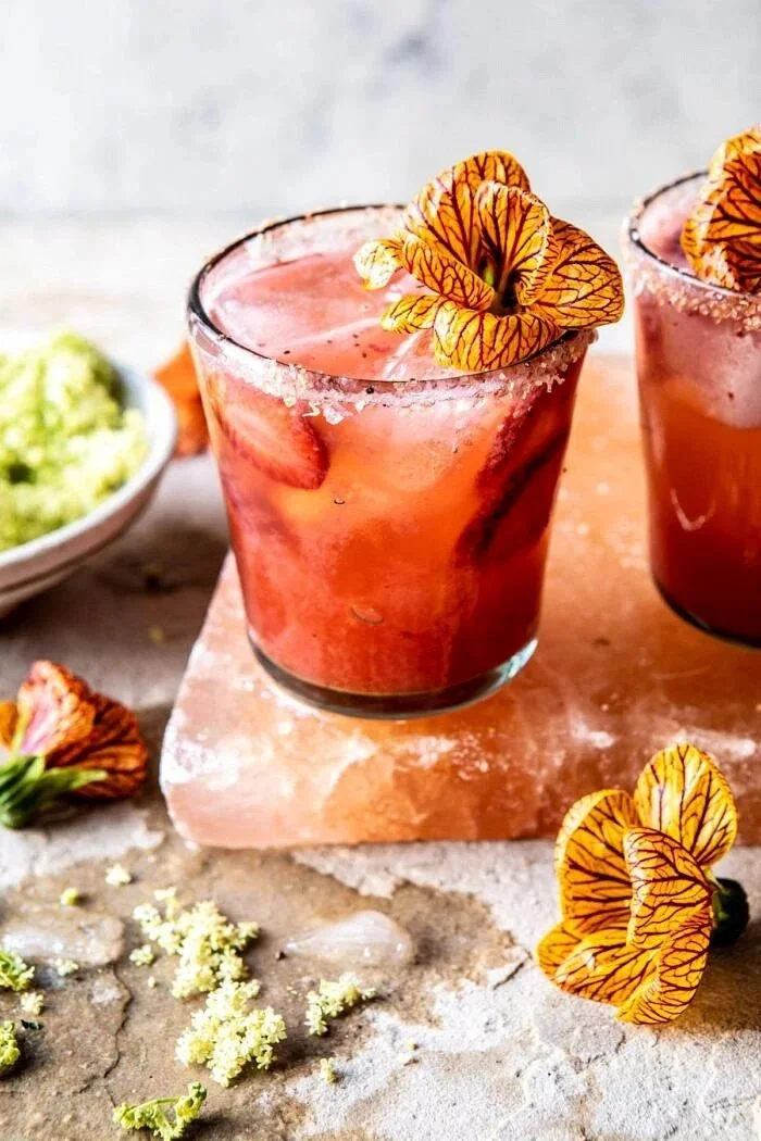 Strawberry hibiscus margarita with ginger, garnished with fresh fruits