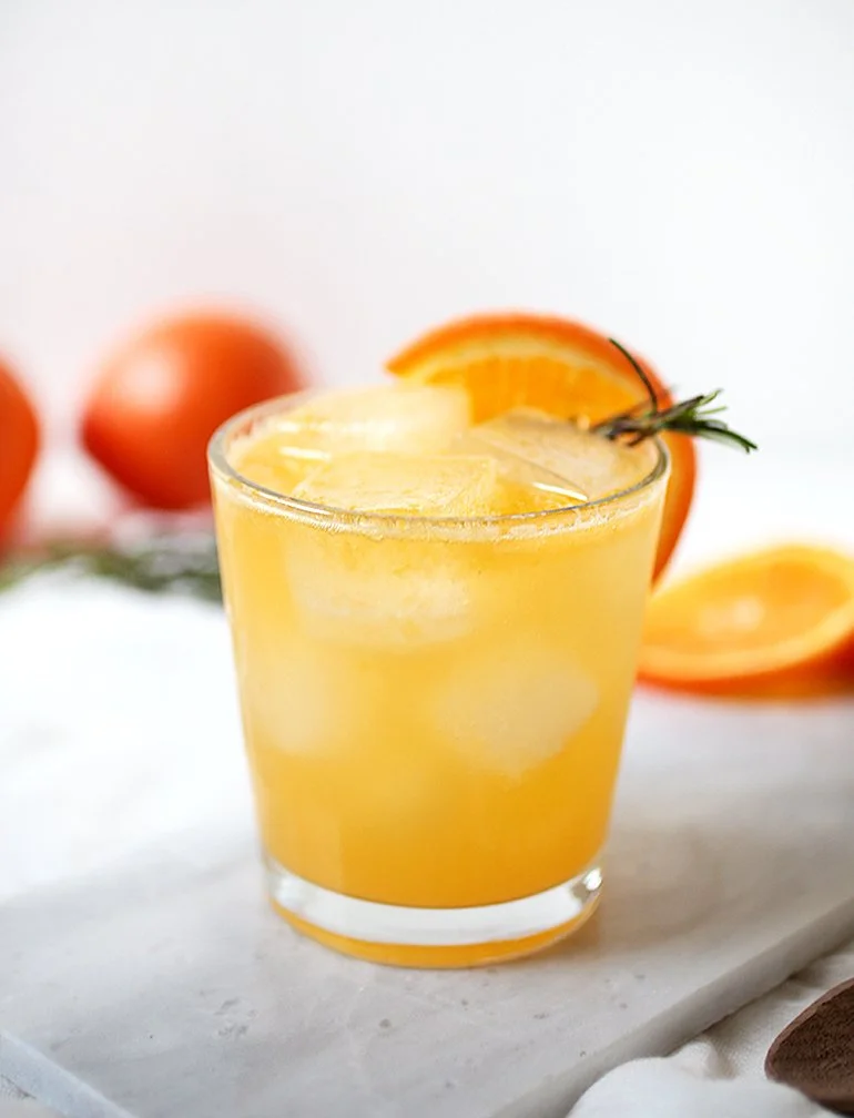 Tangerine Rosemary Mocktail served in a glass with fresh rosemary garnish