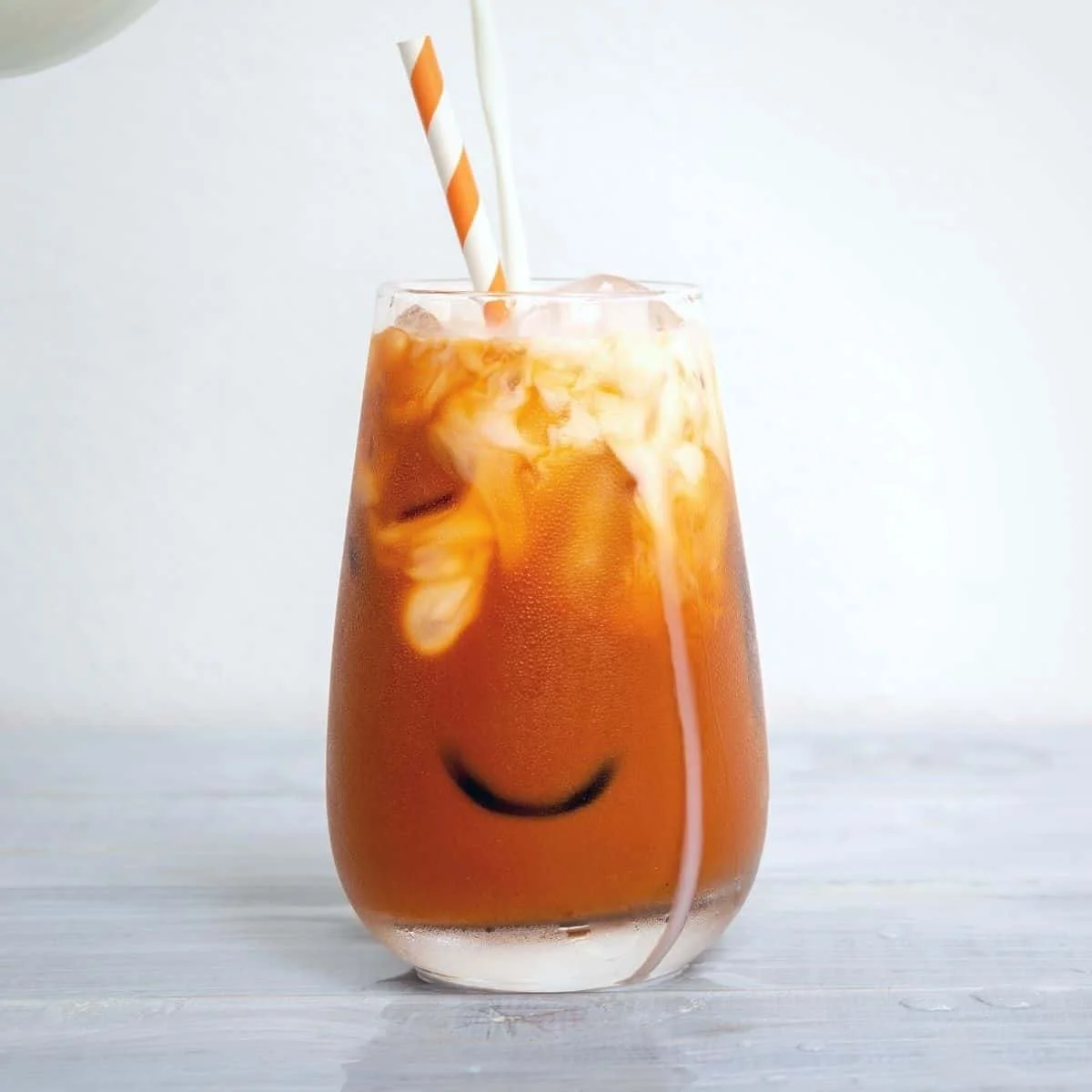 A refreshing glass of Thai Iced Tea with vibrant colors and a creamy texture.
