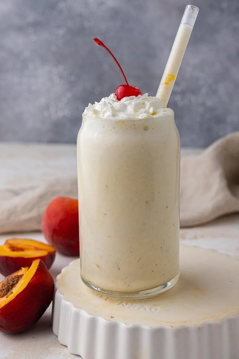 Delicious Chick Fil A peach milkshake with fresh peach garnish