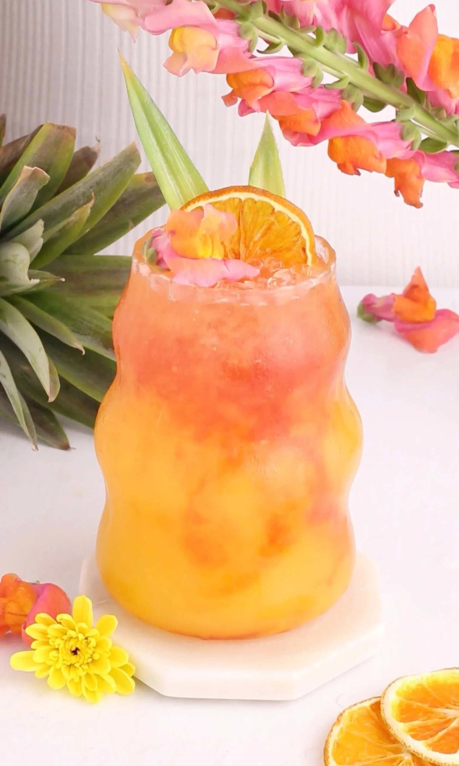 Colorful tropical mocktail made with fresh fruits and garnishes