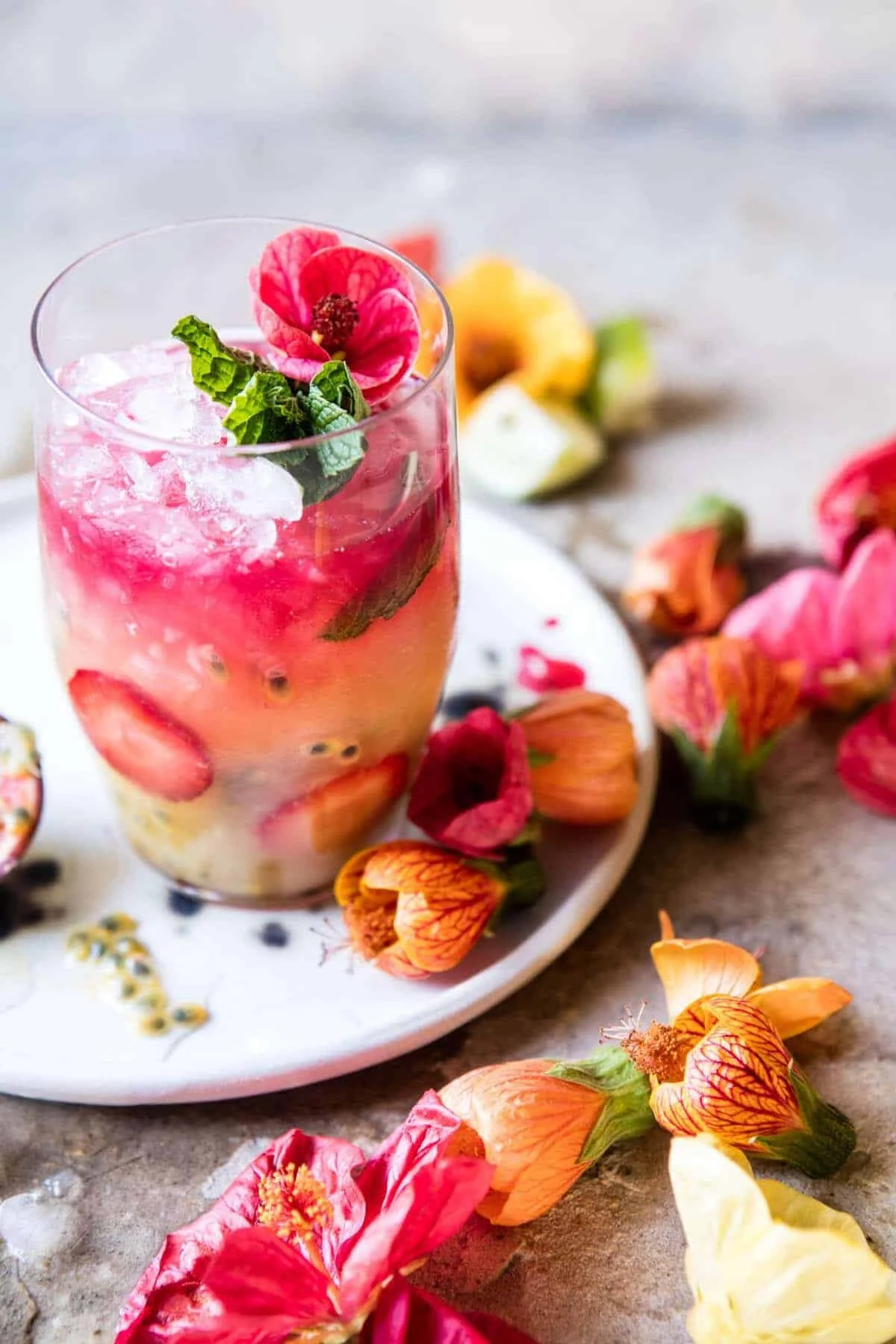 Tropical Strawberry Hibiscus Rum Spitz cocktail garnished with fresh strawberries.