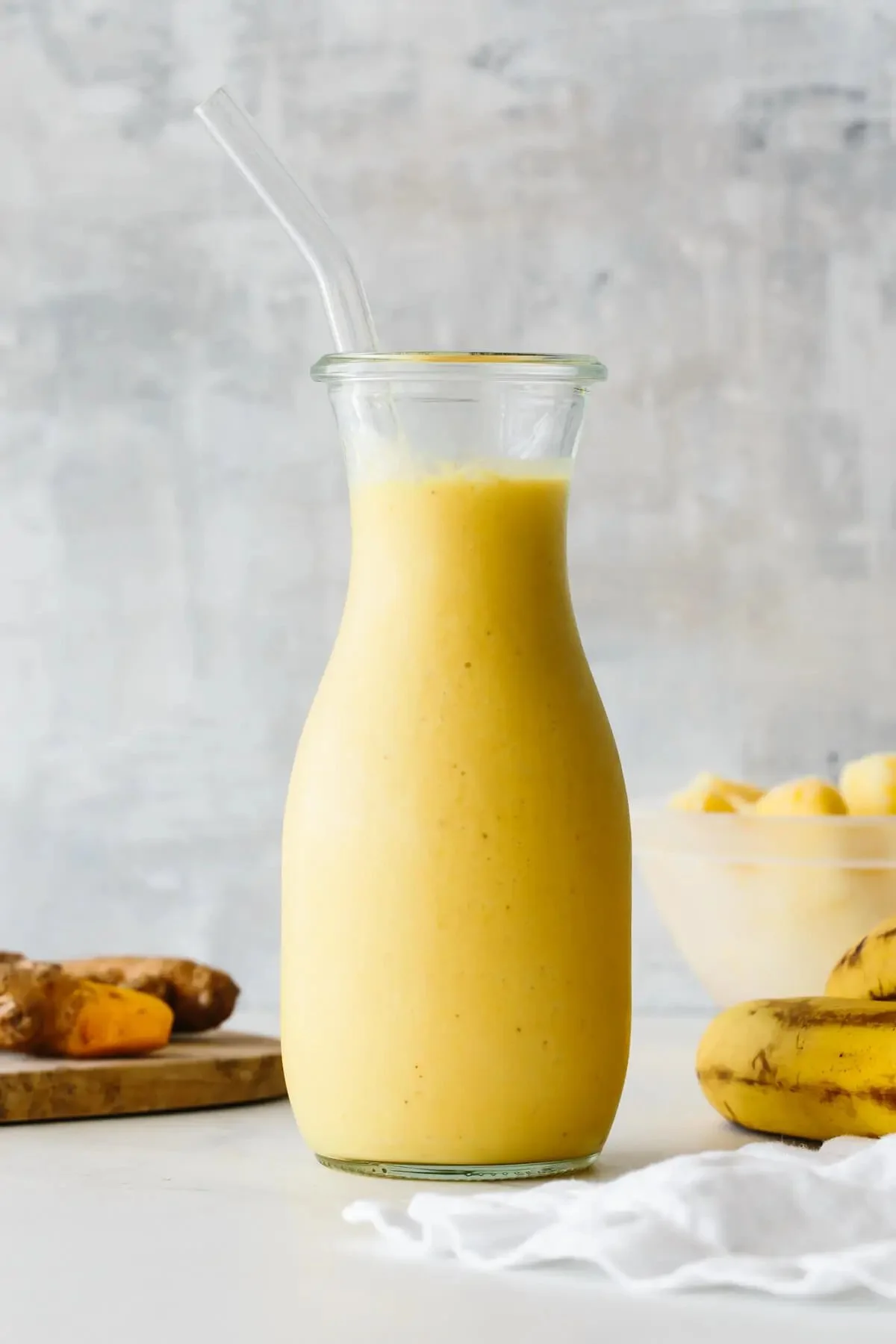 Healthy turmeric smoothie with fruits and spices in a glass