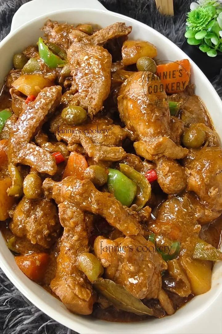 A warm bowl of Chicken Caldereta, a traditional Filipino chicken stew with vegetables.