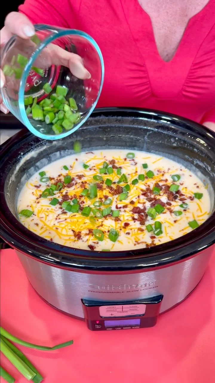 Delicious Crockpot Loaded Potato Soup topped with cheese and green onions.
