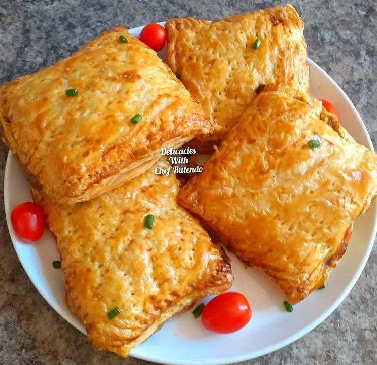Homemade creamy chicken pies served on a wooden table with herbs